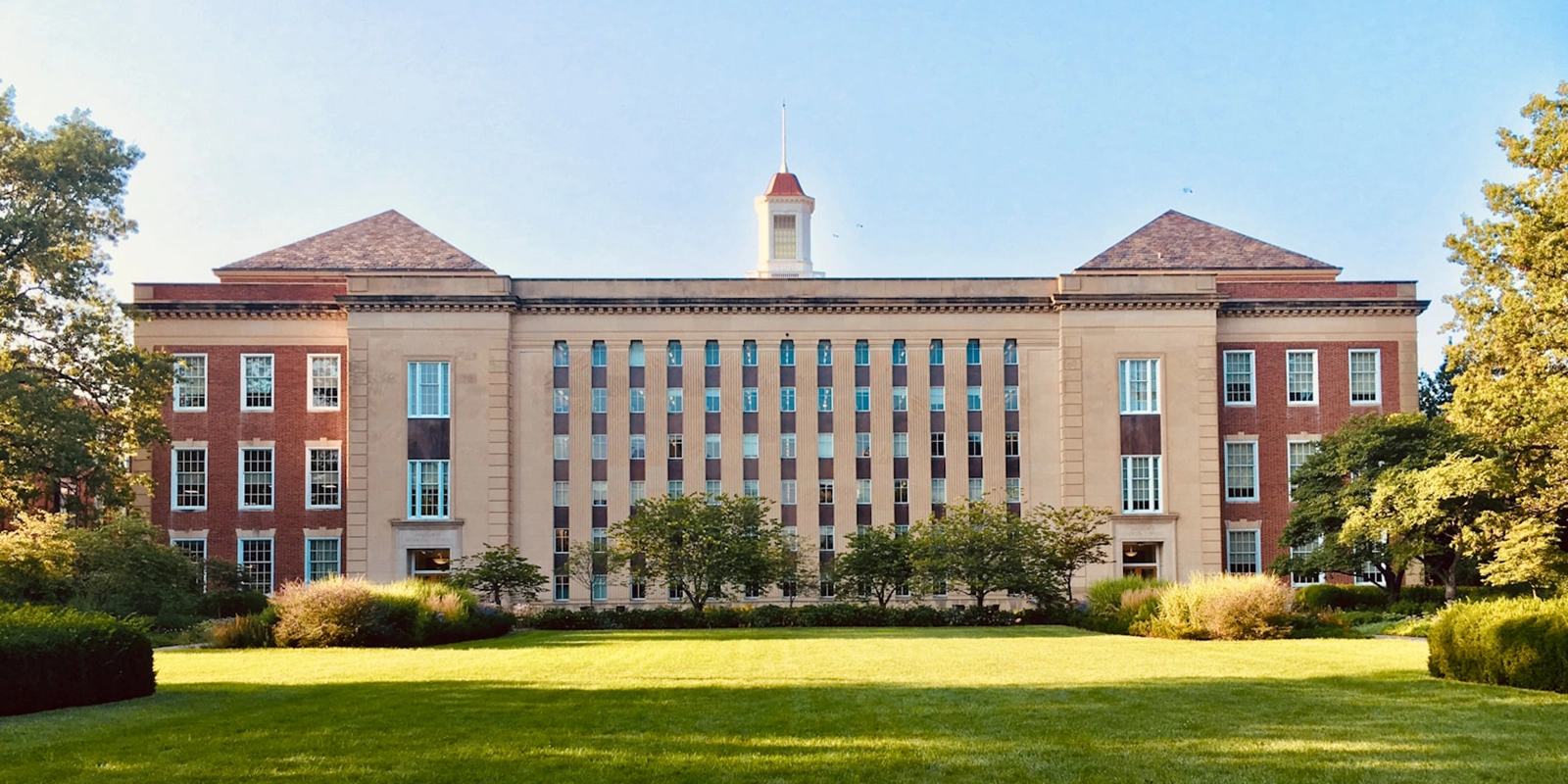 Großes, klassisches Hochschulgebäude mit Park davor