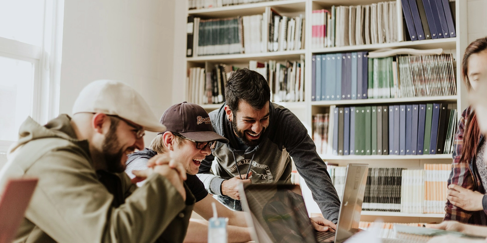 Gruppe lachender Freunde beim Lernen in Bibliothek