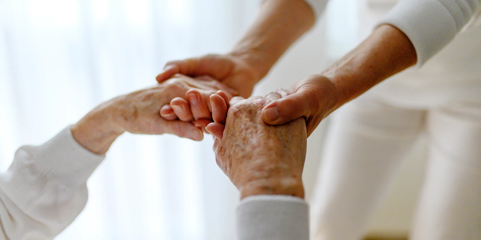 Händedruck zwischen Pflegekraft und Senior