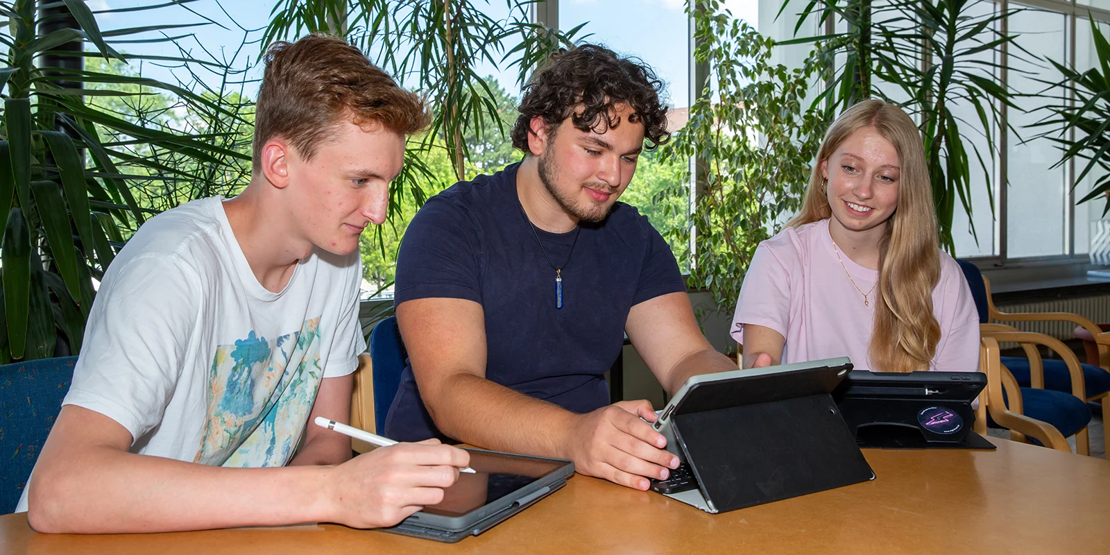 Drei Jugendliche arbeiten gemeinsam an Tablets