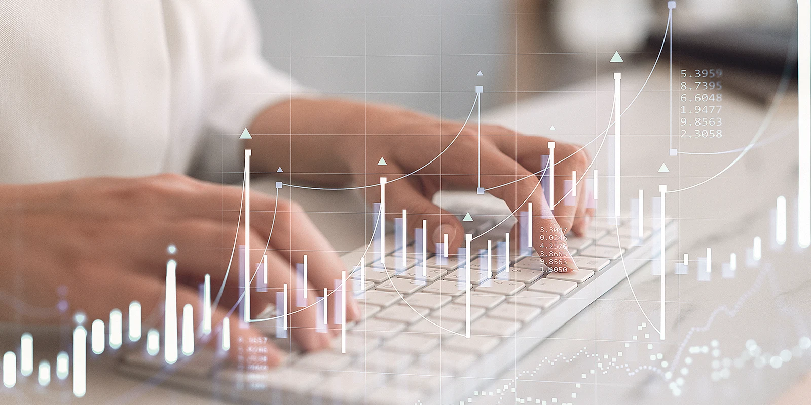 Person tippt Tastatur; Diagramme zeigen Trends